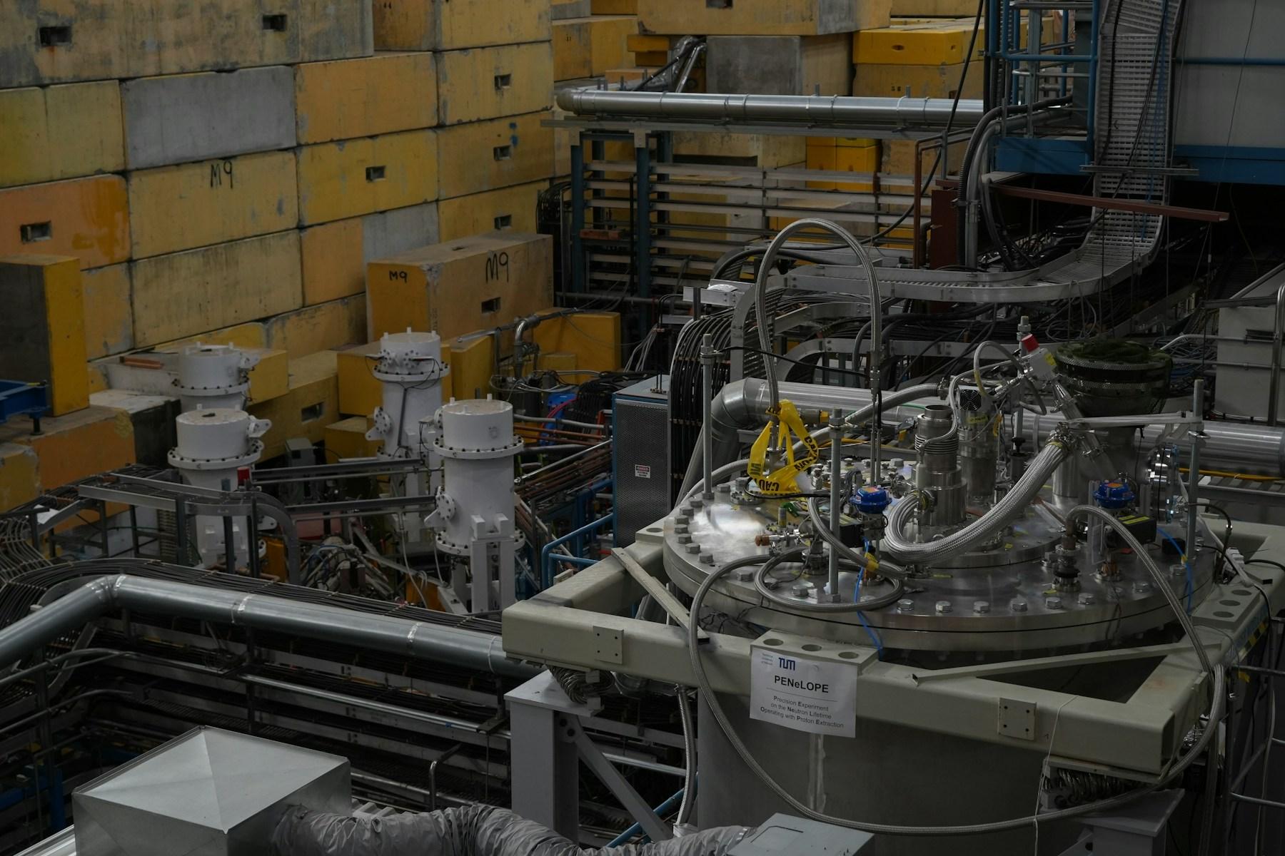 Dense scientific machinery, pipes, and instrumentation inside a physics facility