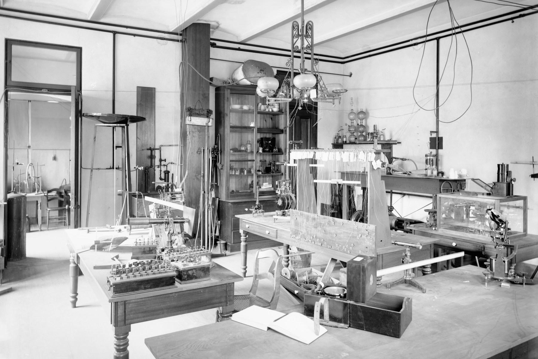 A historic laboratory arranged with scientific instruments and worktables