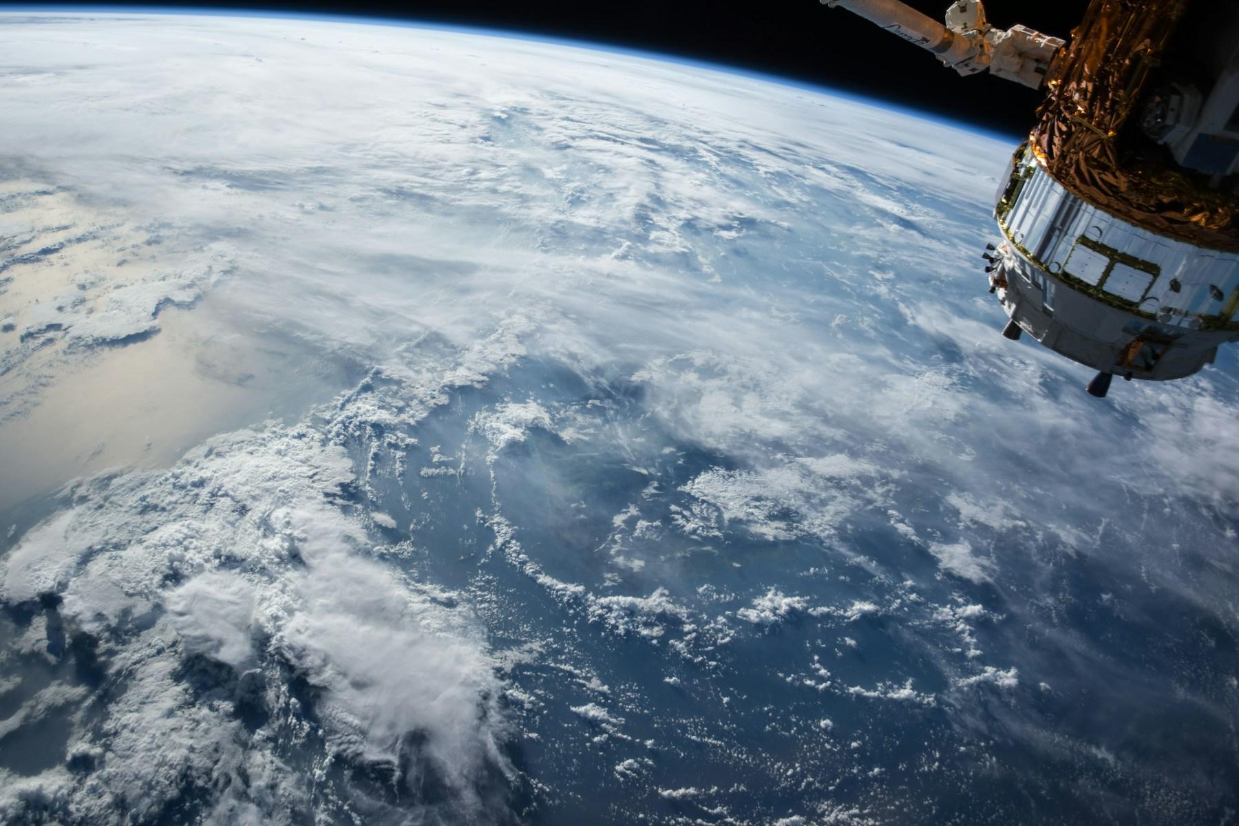 Earth and a spacecraft seen against the blackness of space