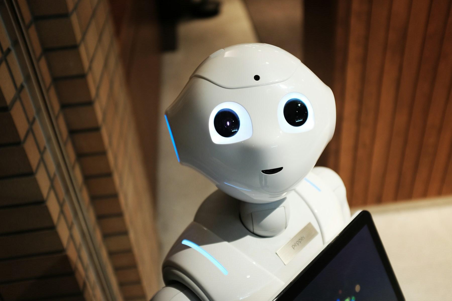 A white humanoid research robot inside an engineering workspace